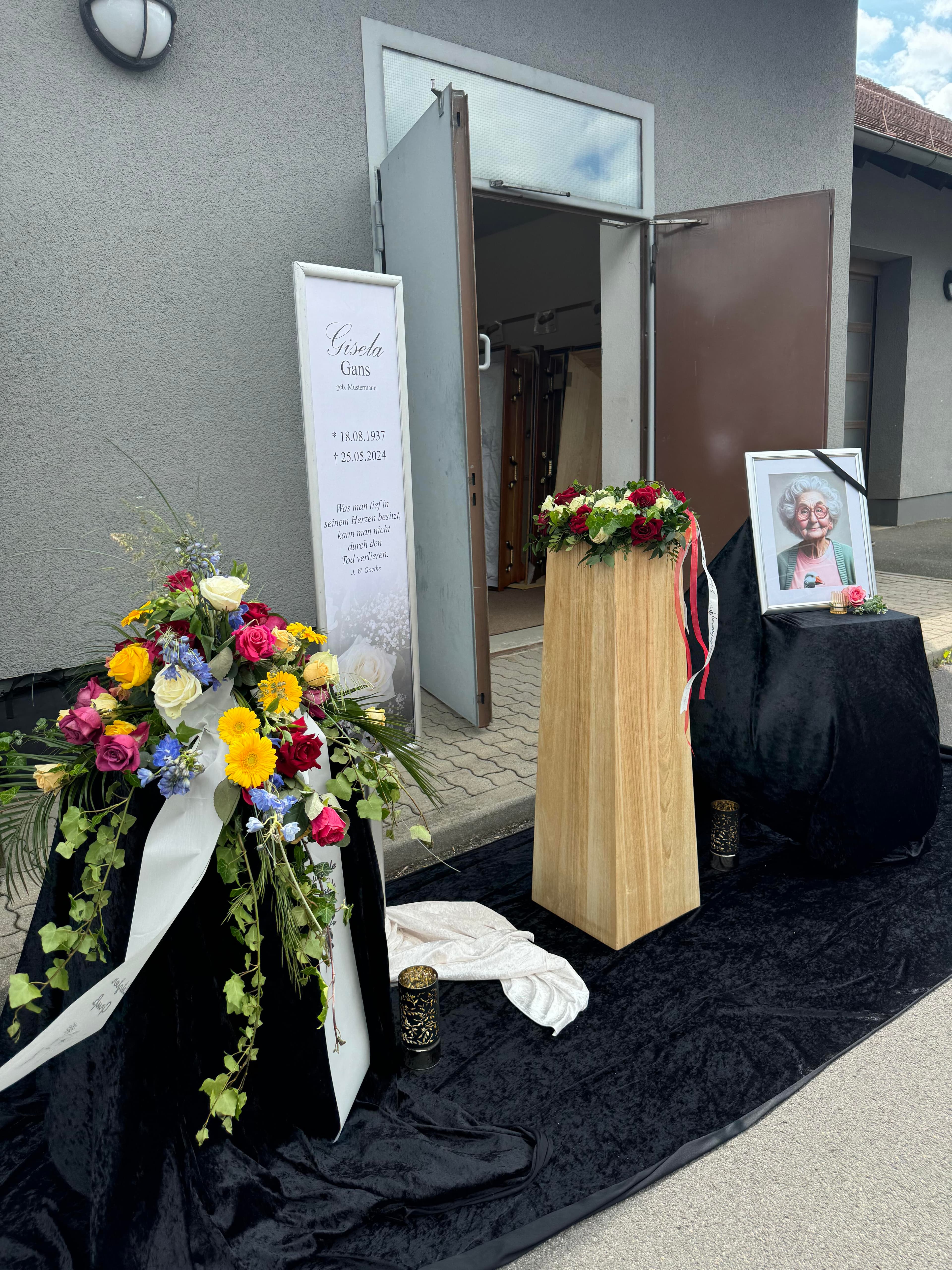 Gedenkstätte mit Blumen und Porträtfoto der Verstorbenen