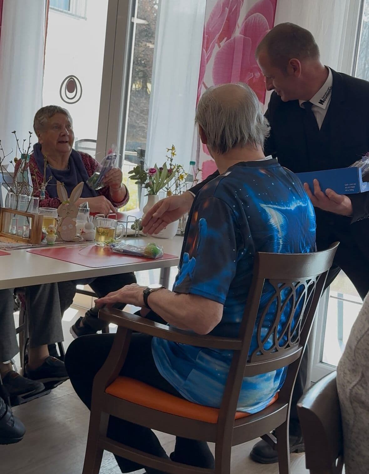 Mitarbeiter überreicht Ostergeschenk am Tisch