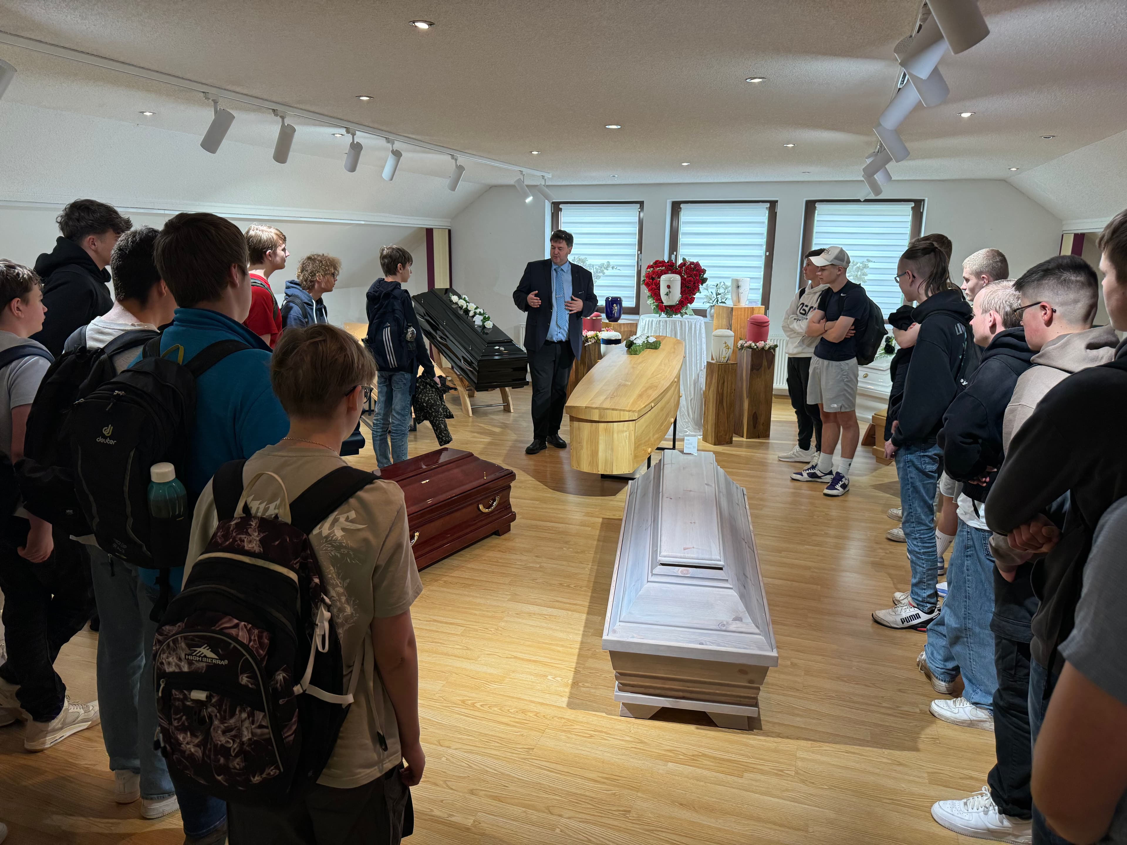 Jugendliche im Ausstellungsraum mit verschiedenen Särgen