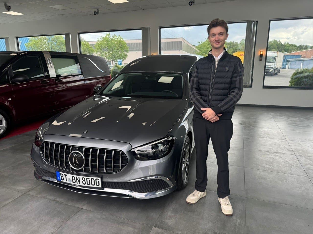 Mann steht neben Mercedes T-Modell im Showroom