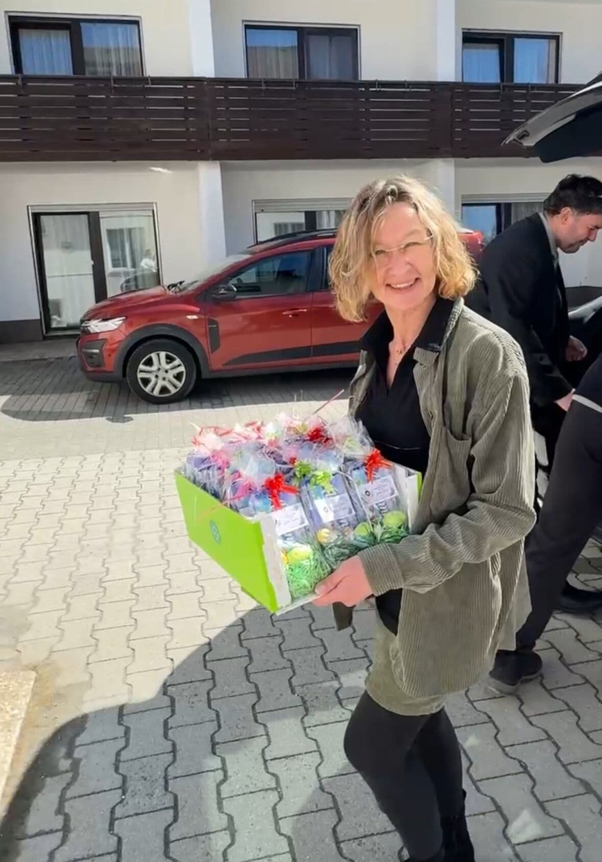 Mitarbeiterin trägt Osterkorb mit Präsenten